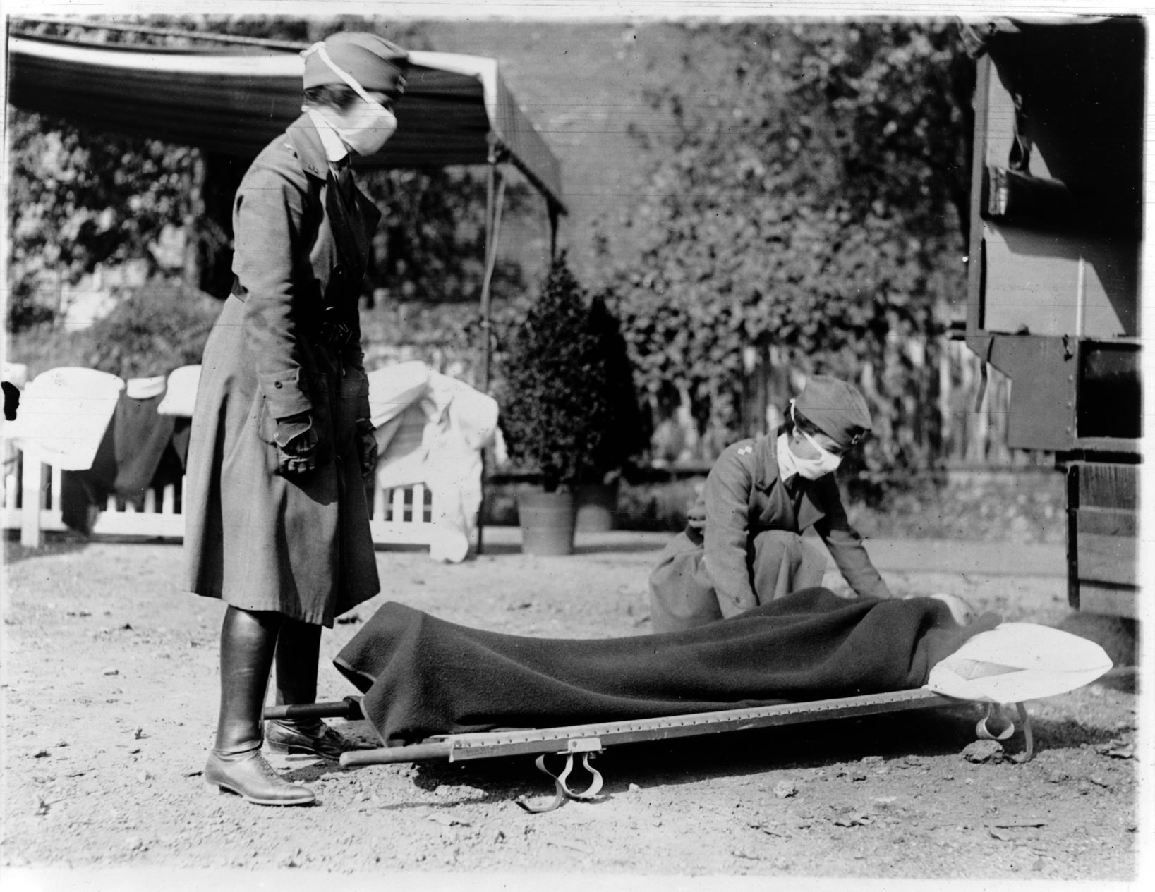 Two Red Cross nurses with person on stretcher